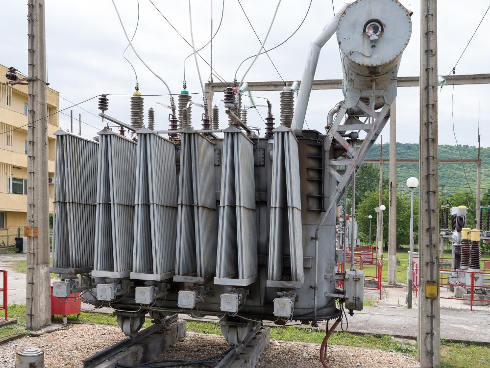 Equipamento de distribuição elétrica em poste com componentes isolantes, contexto visual de O que é a classe de tensão transformador.